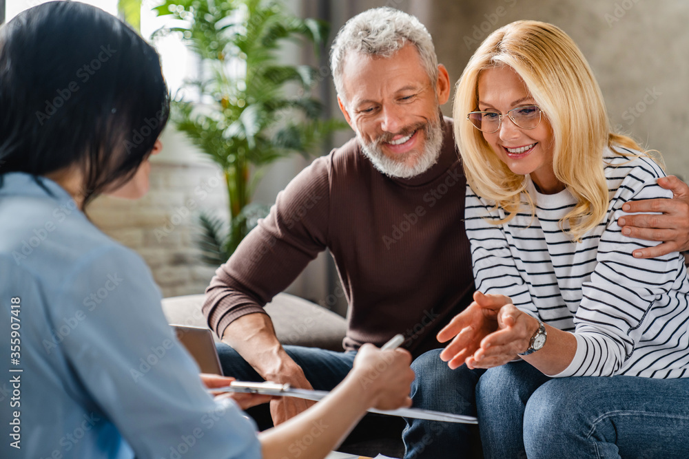 Smiling-couple-having-a-discussion-with-a- financial-advisor-reviewing-documents- and-discussing-financial- planning-options